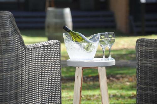 a table with two glasses and a bottle of wine at Quality Hotel Lincoln Green in Auckland