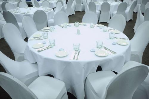 a table set up for a wedding with white tables and chairs at Quality Hotel Lincoln Green in Auckland