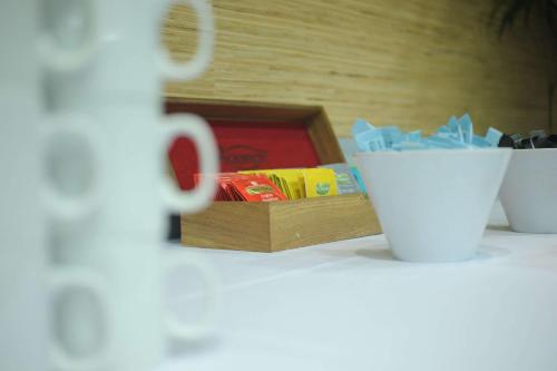 a table with a box of chocolates and a cup at Quality Hotel Lincoln Green in Auckland