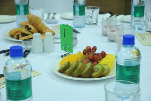 a table with plates of fruit and bottles of water at Quality Hotel Lincoln Green in Auckland