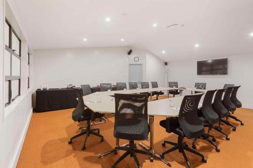 a conference room with a long table and chairs at Quality Hotel Lincoln Green in Auckland