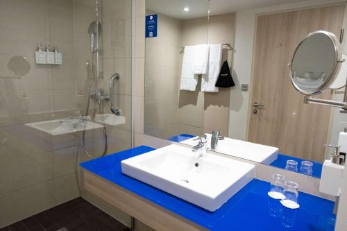 a bathroom with a sink and a shower and a mirror at Park Inn by Radisson Linz in Linz