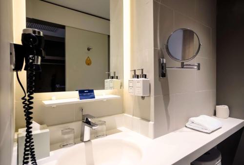 a bathroom with a sink and a mirror at Park Inn by Radisson North Edsa in Manila