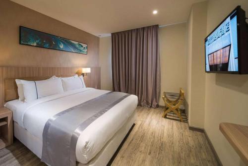 Ένα ή περισσότερα κρεβάτια σε δωμάτιο στο Ramada Encore by Wyndham Chinatown Kuala Lumpur