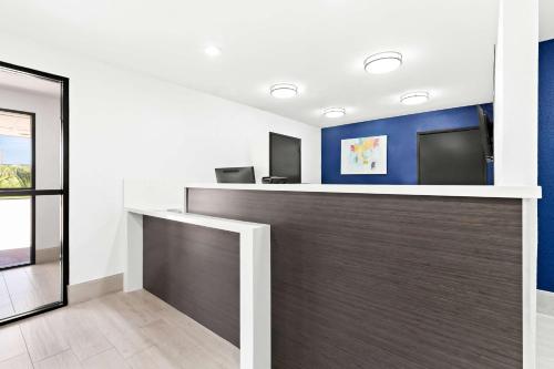an office with a reception counter with blue walls at SureStay Hotel by Best Western Groves in Groves