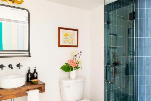 a bathroom with a toilet and a glass shower at Wayfinder Waikiki - Voted Top 10 Best Hotels in Hawaii! in Honolulu