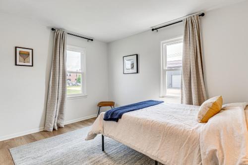 a bedroom with a bed and two windows at Peaceful Robinson Home with Yard, Near Golf Courses! in Robinson