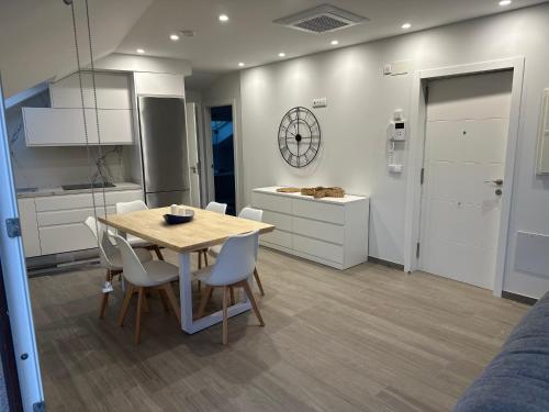 a kitchen and dining room with a table and chairs at Ático mirando o mar in Porto do Son