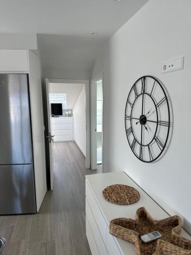 a kitchen with a large clock on the wall at Ático mirando o mar in Porto do Son