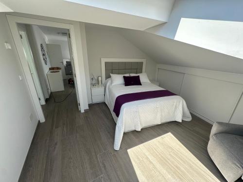 a bedroom with a bed and a couch at Ático mirando o mar in Porto do Son