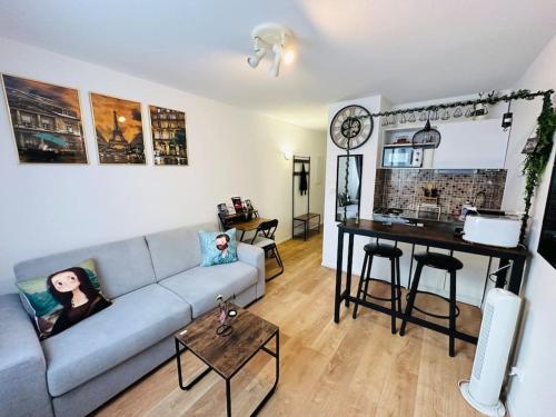 un salon avec un canapé et une table dans l'établissement Studio cozy - Paris La Défense Arena - Courbevoie, à Courbevoie