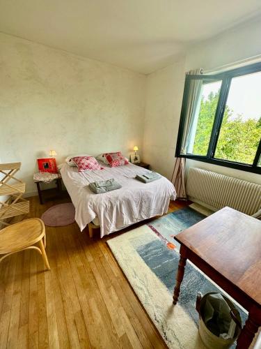 une chambre avec un lit et une grande fenêtre dans l'établissement Villa Californienne du soleil, à La Rochelle