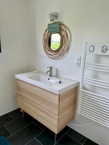 une salle de bain avec un lavabo et un miroir dans l'établissement Villa Californienne du soleil, à La Rochelle