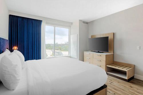 a bedroom with a white bed and a large window at EVEN Hotel Waco - University Area by IHG in Waco