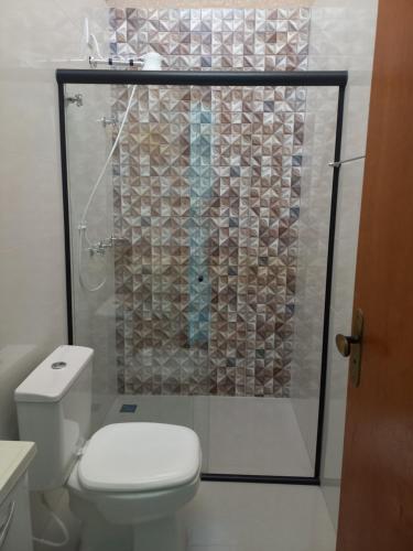 a bathroom with a toilet and a shower with a glass door at Teixeira in Olímpia