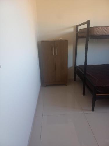 a bedroom with a bunk bed and a wooden cabinet at Teixeira in Olímpia