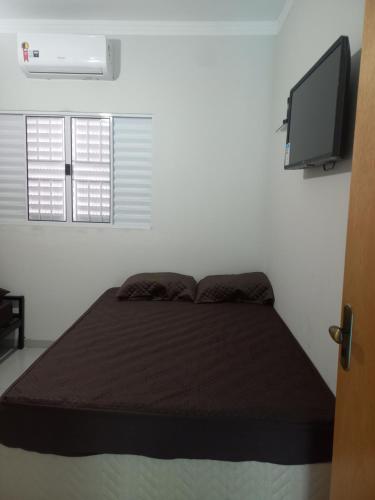a bed in a room with a television and a bed sidx sidx sidx at Teixeira in Olímpia