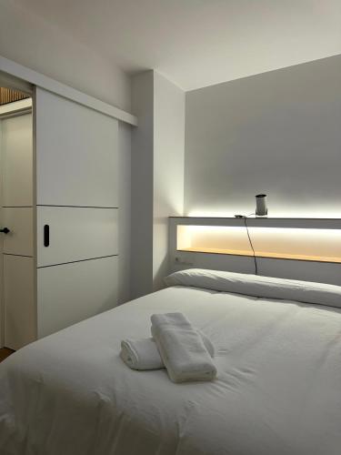 a white bedroom with a bed and a dresser at Kilometro 22 Luxury in Padrón