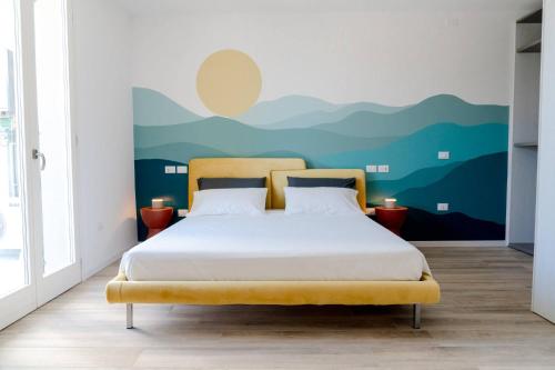 a bedroom with a bed with a mountain mural on the wall at InLoco - Natural Experience in Acqualagna