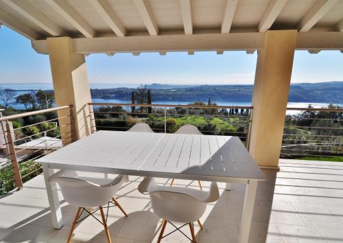 a white table and chairs on a deck with a view at Villa Maria in Salò