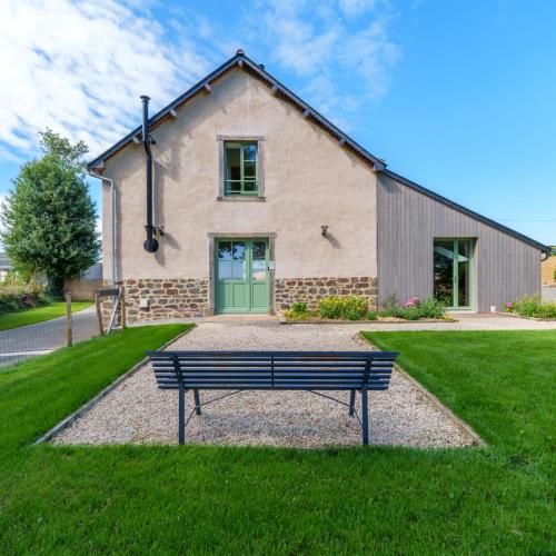 a bench sitting in front of a house at Grange moderne près de Rennes avec jolie vue ! in Gévezé