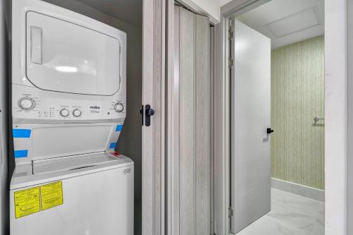a washer and dryer in a room with a door at Monaco Residences Piantini in Santo Domingo