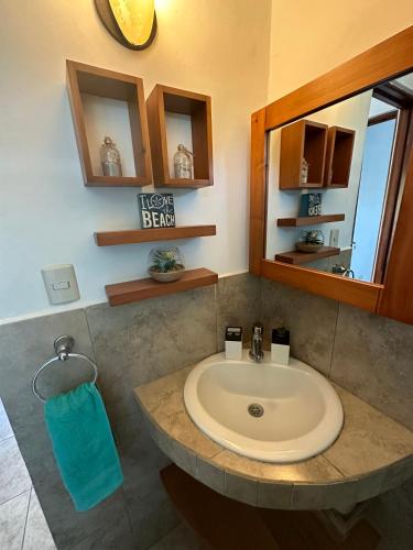 a bathroom with a sink and a mirror at Villa in Monterrico in El Garitón