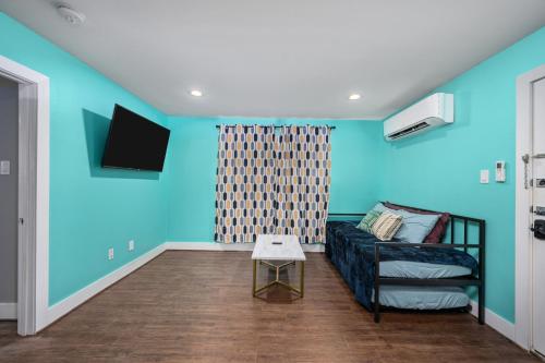 a living room with blue walls and a couch at Lovely 1BR Apartment near Medical Center & NRG in Houston