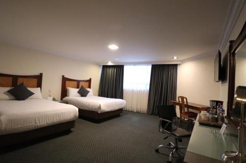 a hotel room with two beds and a window at Best Western Plus Gran Marques in Toluca