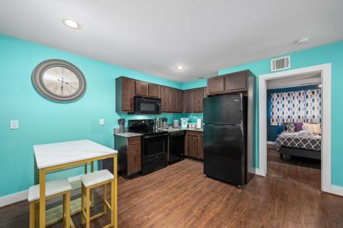 a kitchen with blue walls and a black refrigerator at Lovely 1BR Apartment near Medical Center & NRG in Houston