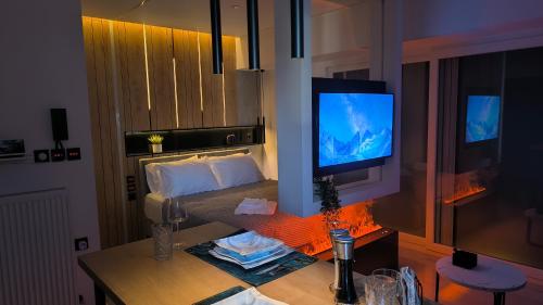een kamer met een bed en een televisie op een tafel bij Larisa Absolute Suites, Sky View Smart Home in Larisa