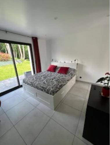 une chambre avec un lit avec des oreillers rouges et une fenêtre dans l'établissement Un Coin Paisible, à Lantheuil