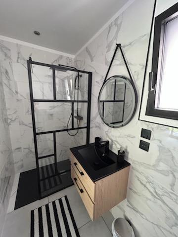 une salle de bain avec un lavabo et un miroir dans l'établissement Un Coin Paisible, à Lantheuil