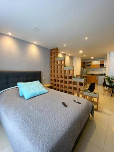 a bedroom with a large bed with a blue pillow at Apartamento en Pasto in Pasto