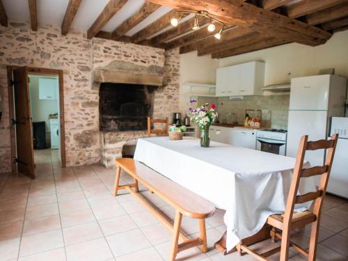 a kitchen and dining room with a table and chairs at Gîte de charme rénové avec cheminée, terrasse et proche randonnées - Capacité 13 pers. - FR-1-410-179 in Saint-Léonard-des-Bois