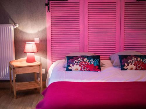 a bedroom with a pink headboard and a bed with pillows at Gîte de charme rénové avec cheminée, terrasse et proche randonnées - Capacité 13 pers. - FR-1-410-179 in Saint-Léonard-des-Bois
