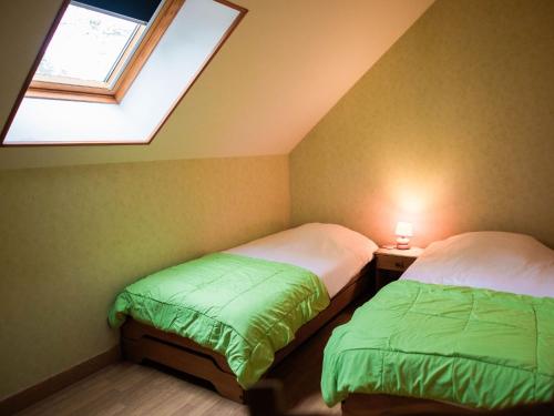 two beds in a small room with a window at Gîte de charme rénové avec cheminée, terrasse et proche randonnées - Capacité 13 pers. - FR-1-410-179 in Saint-Léonard-des-Bois