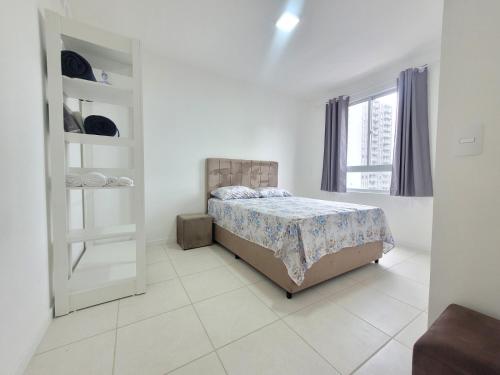 um quarto branco com uma cama e uma janela em Apartamento novo, vista mar, 150m da praia em Piçarras