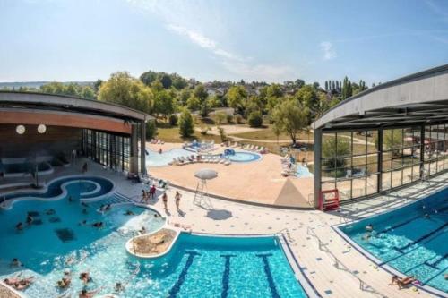 une vue aérienne d'une piscine dans un complexe hôtelier dans l'établissement Le lynx boréal, centre historique avec jardin, à Lons-le-Saunier