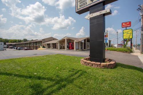 a sign on a pole in the grass in front of a store at Glenstone place extended stay motel in Springfield