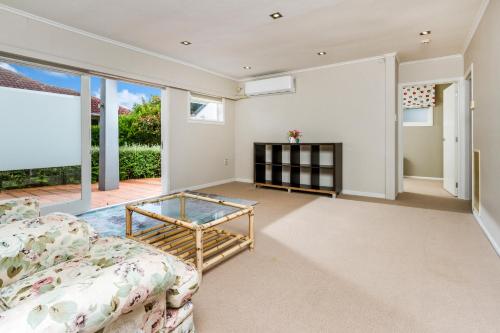 a living room with a couch and a glass table at Award winning house in Auckland