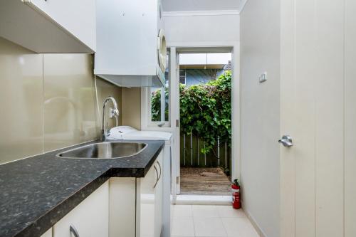 a kitchen with a sink and a door to a yard at Award winning house in Auckland