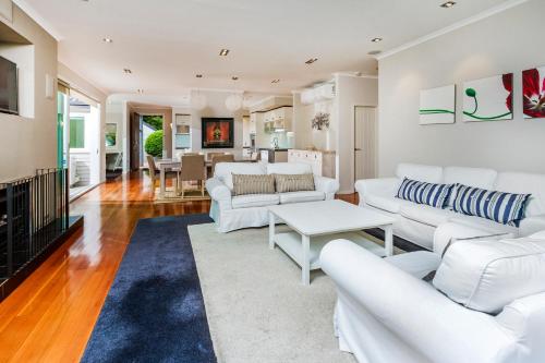 a living room with white couches and a table at Award winning house in Auckland