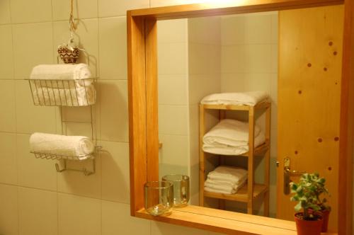 a mirror in a bathroom with a stack of towels at Tesino Appartamenti in Castello Tesino