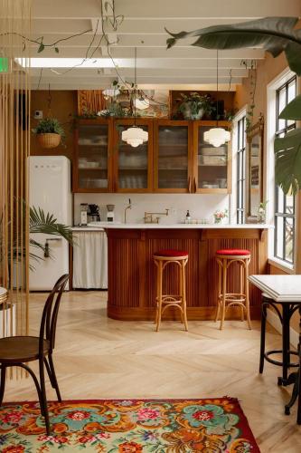 a kitchen with wooden cabinets and chairs and a table at Hotel No-Vacancy in Kansas City