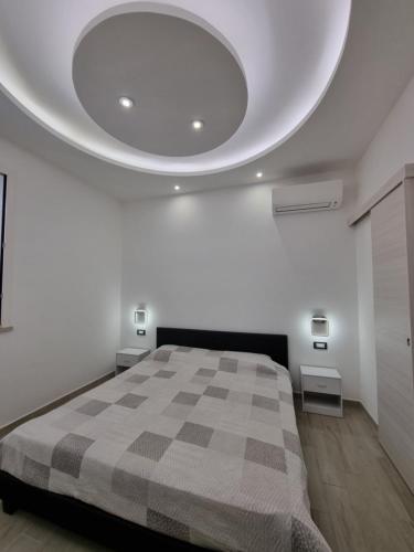 1 dormitorio blanco con 1 cama con manta a cuadros en Maria Blue House, en Portopalo di Capo Passero