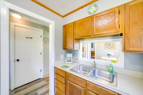 Una cocina con gabinetes de madera y un fregadero. en Wayland Retreat with Deck Walk to Downtown!, en Wayland