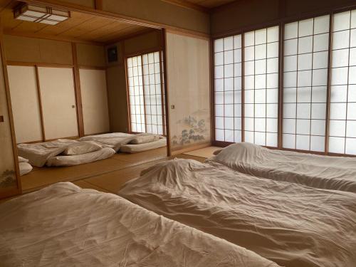 伊那市Irori 新山ふるさと体験館的带窗户的客房内设有四张床。
