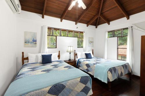 two beds in a room with two windows at Angels Mar Villa Hermosa 2b2b European Villa in Playa Hermosa