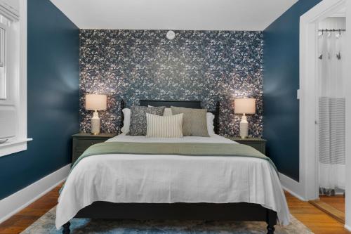 a bedroom with blue walls and a bed with two lamps at The Aurora Inn & Cottages in Bartlett